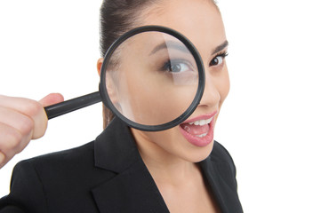 Looking through magnifying glass. Beautiful young woman looking