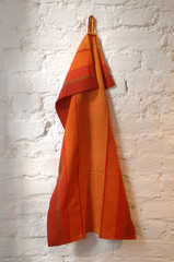 Orange gemustertes Geschirrtuch / Handtuch an der Wand hängend