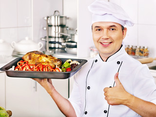 Man in chef hat cooking chicken