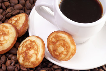Kaffeetasse und Kaffeebohnen mit Gebäck