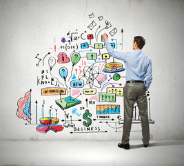Businessman drawing sketches on wall