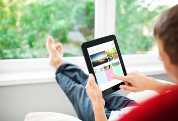 Man using tablet on sofa at home