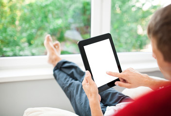 Man using tablet on sofa at home