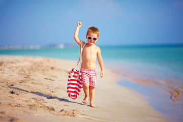 cute kid boy walking the sea beach