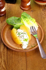 Potato with cottage cheese, salad and fork