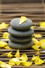 Spa composition of stones and yellow ranunculus petals