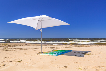 White parasol on the beach of Baltic Sea in Sobieszewo