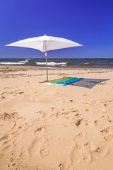 White parasol on the beach of Baltic Sea in Sobieszewo
