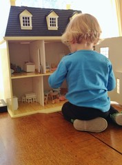 young girl playing with dollhouse