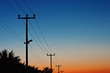 Electric power lines against a dawn sky - Powered by Adobe