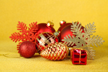 Fototapeta na wymiar Christmas balls and small gift on yellow background