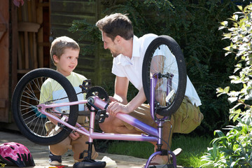 Father And Son Mending Bike Together