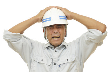 頭を抱える男性作業員
