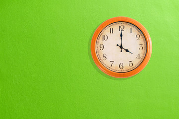 Fototapeta na wymiar Zegar pokazujący godzina czwarta na zielone ściany