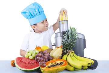 Cute boy is making fruit juice