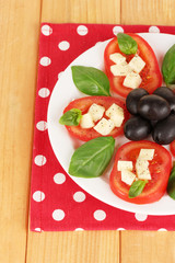Cheese mozzarella with vegetables in plate on table