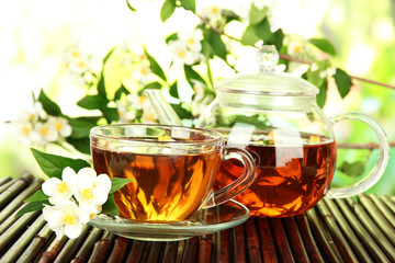 Cup of tea with jasmine, on bamboo mat, close-up