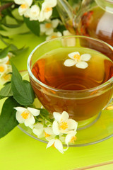 Cup of tea with jasmine, on wooden table, close-up