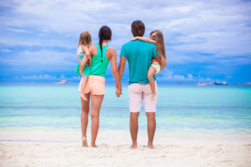 Back view of young family of four looking to the sea in