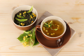 Cup of tea with linden on napkin   wooden table