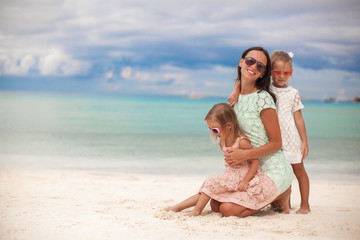 Fashion mother and two her adorable daughters at exotic beach on