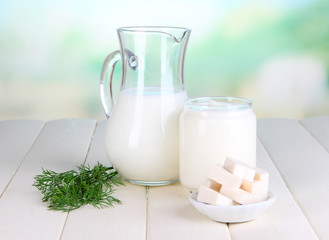 Fresh dairy products on wooden table on natural background