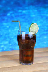 Tasty cocktail on swimming pool background