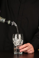 Bartender making cocktail on bright background, close-up