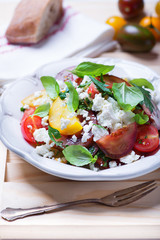 salad with red, yellow and black tomatoes and feta cheese
