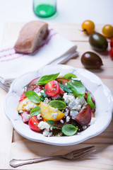 salad with red, yellow and black tomatoes and feta cheese