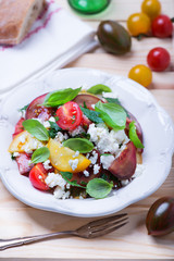 salad with red, yellow and black tomatoes and feta cheese