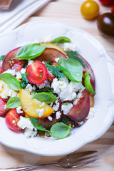 salad with red, yellow and black tomatoes and feta cheese