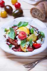 salad with red, yellow and black tomatoes and feta cheese
