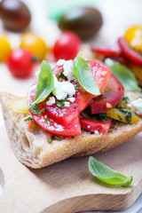 sandwich with red, yellow and black tomatoes and feta cheese