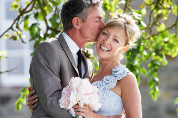 Romantic Bride And Groom Embracing Outdoors