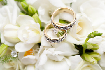 Obraz na płótnie Canvas two wedding rings on bridal bouquet
