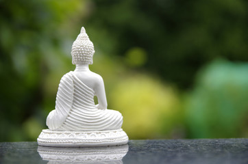 Weisse Buddhafigur von hinten schaut in die Ferne