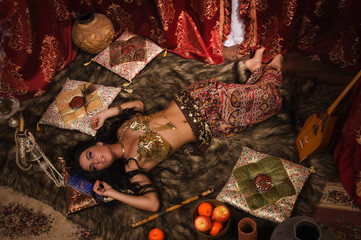 Beautiful belly dancer in the arabic harem interior