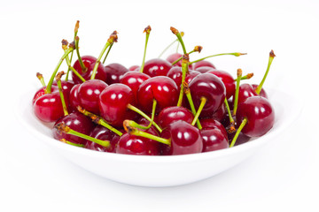 White dish up to the top filled with red ripe cherry