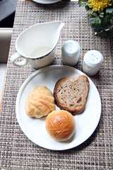 Hight view Bread in a white dish and Near cup milk