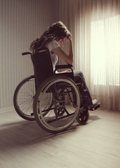 Fototapeta na wymiar Crying woman sitting in wheelchair
