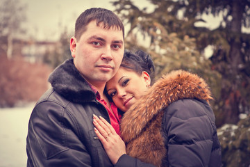 Fototapeta premium Portrait of a young loving couple in the winter forest