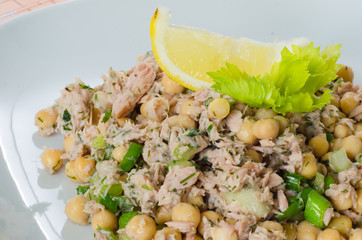 Close up on a dish of chickpea salad with tuna and herbs
