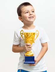 Little boy celebrates his golden trophy