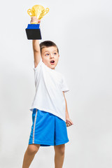 Little boy celebrates his golden trophy