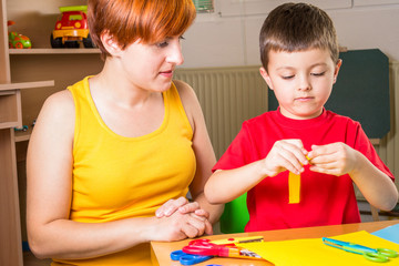 Mother cuts paper with his son