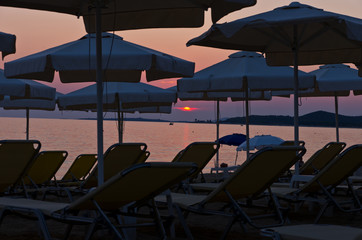 Chairs and parasols on a beach at sunset