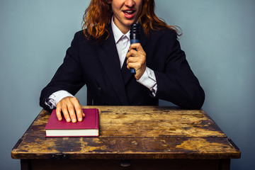 Businesswoman with microphone and book