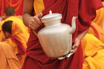 Tibetan tea teapot in the hands of a monk in Nepal - 55409060