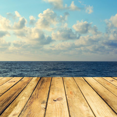 Wooden deck floor over beautiful sea and sky background